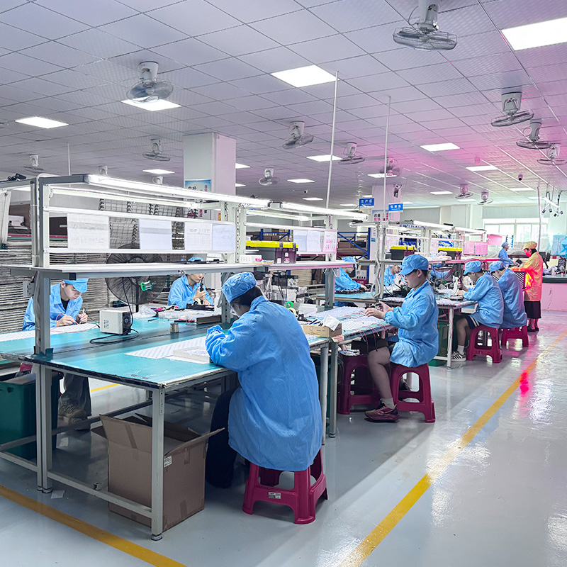 Skilled workers assembling red light therapy equipment at RICOVSUN factory